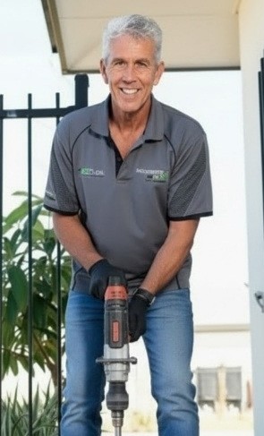 Smiling tradie using jackhammer outside home