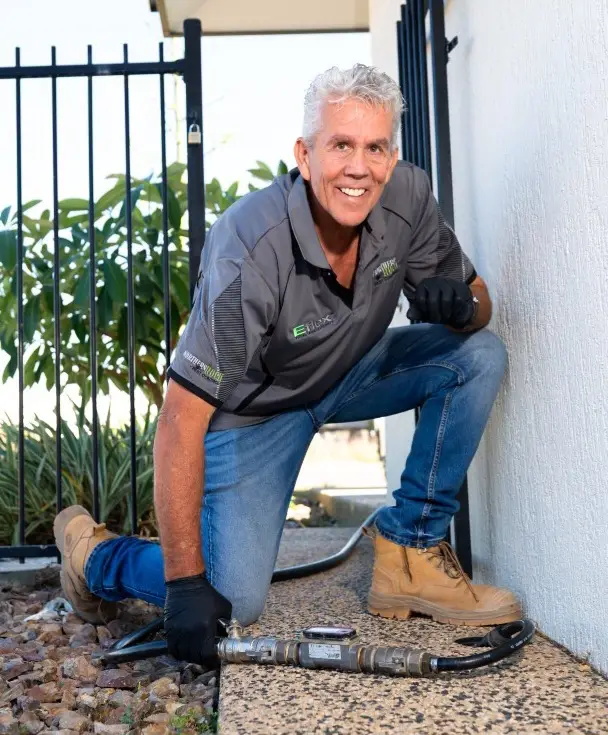Technician kneeling beside outdoor gas meter installation